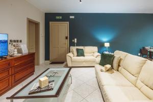 a living room with two couches and a tv at Savoy Signature Stays in Il-Gżira