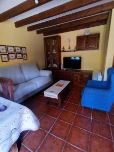 a living room with a couch and a tv at Casa Belarmina in Cangas de Onís