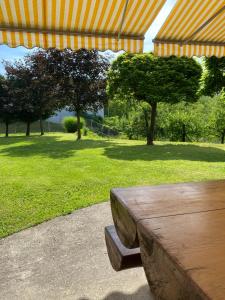 a wooden bench sitting under a tent in a park at Apartma Ložice in Deskle