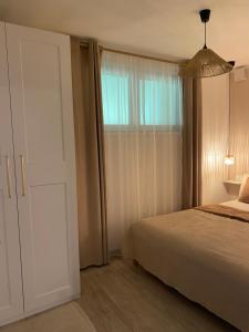 a bedroom with a bed and a large window at Apartma Ložice in Deskle