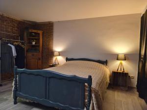 a bedroom with a blue bed and two lamps at Cocoon Hébergement Wellness in Chimay