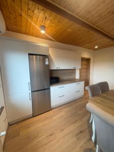 a kitchen with white cabinets and a stainless steel refrigerator at Apartament u Anitki in Trzebnica