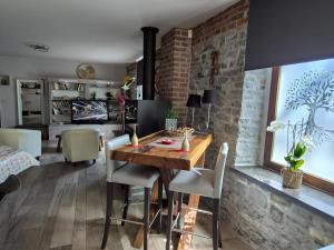 a kitchen and dining room with a brick wall at Cocoon Hébergement Wellness in Chimay