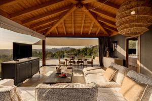 a living room with a couch and a table at Petra Segreta Resort & Spa in San Pantaleo