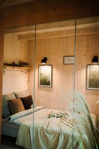 a bedroom with a bed in a wooden wall at Rajsco - domek nad Jeziorem Budzisławskim in Tręby Stare