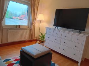 a living room with a large television on a dresser at Nordapart Anne Bessrich in Butjadingen