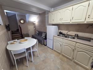 a small kitchen with a table and a white refrigerator at Casa Centro Montargil in Montargil +13 photos