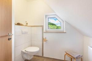 a bathroom with a toilet and a window at Ferienhof Schade in Eslohe +66 photos