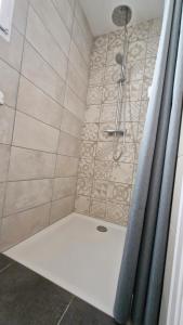 a bathroom with a shower with a shower curtain at Studio La passagère in Plouvorn +13 photos