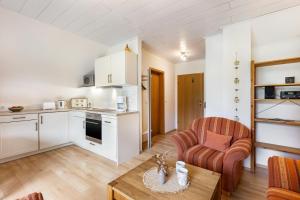 a kitchen and living room with a table and a chair at Ferienhof Schade in Eslohe