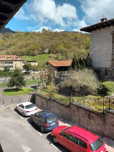 two cars parked in a parking lot next to a building at Casa Belarmina in Cangas de Onís