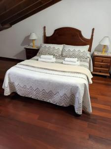 a bedroom with a large bed and two night stands at Casa Belarmina in Cangas de Onís