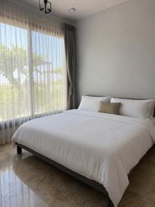 a white bed in a bedroom with a large window at Zahret Al Roman in Sayq +19 photos