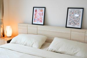 a bedroom with a bed and two framed pictures on a shelf at Walking distance Thunder Dome in Ban Bang Phang