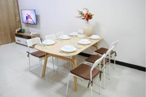 a dining room table with chairs and a vase with flowers at Walking distance Thunder Dome in Ban Bang Phang
