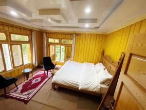 a bedroom with a bed and a chair in it at Alpine Resort Khaplu in Khaplu