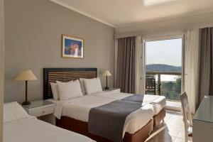 a hotel room with two beds and a window at Ariti Grand Hotel in Corfu