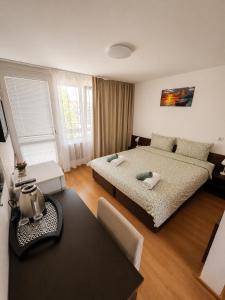 a bedroom with two beds and a table in it at Family Hotel Yulian in Kranevo