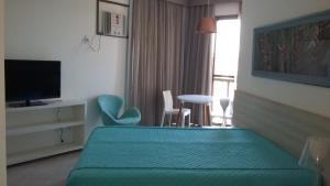 Habitación de hotel con cama, mesa y sillas en Condado Aldeia dos Reis 114 e 213 en Mangaratiba