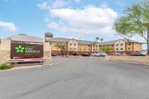 a building with a sign in the middle of a street at Extended Stay America Select Suites - Phoenix - Deer Valley in Phoenix