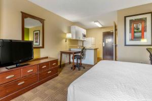 a hotel room with a bed and a flat screen tv at Extended Stay America Select Suites - Phoenix - Deer Valley in Phoenix