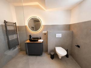 a bathroom with a toilet and a sink and a mirror at Elion Hotel Siegen in Siegen +64 photos