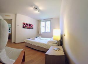 a bedroom with a bed and a table and a lamp at Golfo Gabella Lake Apartments in Maccagno Superiore +54 photos