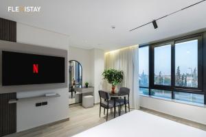 a living room with a tv and a table with chairs at Flexistay Sheikh Zayed in Sheikh Zayed