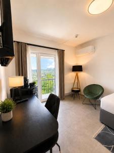 a living room with a bed and a large window at Elion Hotel Siegen in Siegen