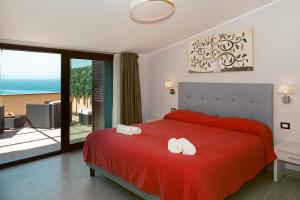 a bedroom with a red bed with two white towels on it at Meublé Leonetti in Palinuro