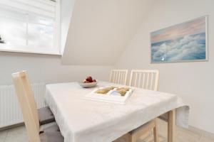 a table with a book and a bowl of fruit on it at Meerzeit Fehmarn in Wulfen auf Fehmarn