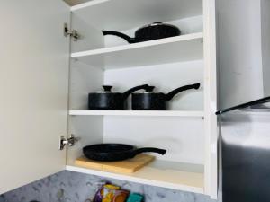 a kitchen pantry with black pots and pans at Deluxe One-Bedroom Apartment, Central in Swindon +55 photos