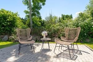 three rattan chairs and a table with a vase of flowers at Möwennest in Vitzdorf