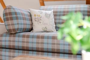 a plaid couch with a pillow and a plant at Möwennest in Vitzdorf