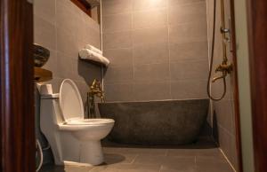 a bathroom with a toilet and a bath tub at Lăng Cô Plaza in Thôn An Hảo +8 photos