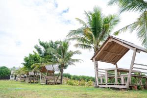 a row of bamboo huts next to palm trees at Lăng Cô Plaza in Thôn An Hảo