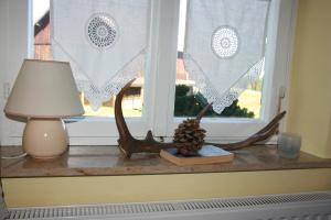 a window with a table with a lamp and a candle at Ferienwohnung Ulrike in Steingaden