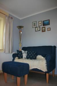 a blue couch and a chair in a living room at Ferienwohnung Ulrike in Steingaden