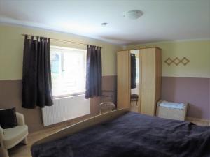 a bedroom with a large bed and a window at Ferienwohnung Ulrike in Steingaden +13 photos