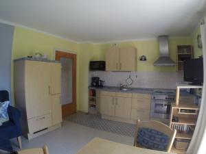 a kitchen with yellow walls and wooden cabinets at Ferienwohnung Ulrike in Steingaden