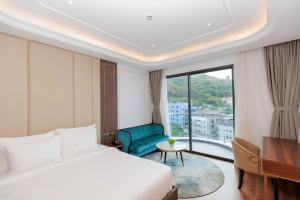 a hotel room with a bed and a large window at Oyster Bay Vũng Tàu - Seaside Pool Escape in Vung Tau +41 photos