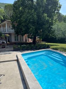 a large blue swimming pool in front of a house at Božič Residence in Vipava