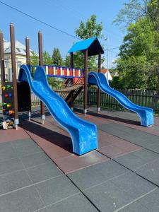 a playground with a blue slide and an umbrella at Retro chalupa Sobkovice in Sobkovice