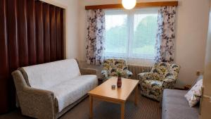a living room with a couch and two chairs and a table at Retro chalupa Sobkovice in Sobkovice