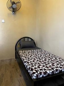 a bed sitting in a room with a fan at Ghazrins Garuda Hotel in Johor Bahru