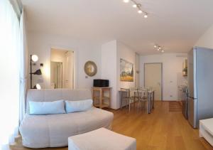 a living room with a white couch and a table at Golfo Gabella Lake Apartments in Maccagno Superiore
