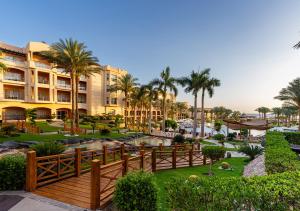 a view of a resort with palm trees and a fence at Tropitel Sahl Hasheesh in Hurghada