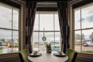 a table with chairs in front of a window at The Clyffe Hotel in Lowestoft