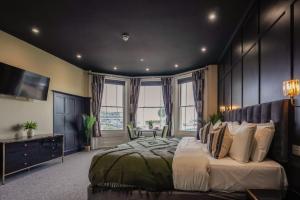 a bedroom with a large bed and a desk and window at The Clyffe Hotel in Lowestoft