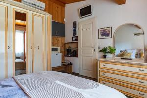 a bedroom with a bed and a dresser and a kitchen at Les Issignols - Chambre d'hotes in Colombier-le-Vieux